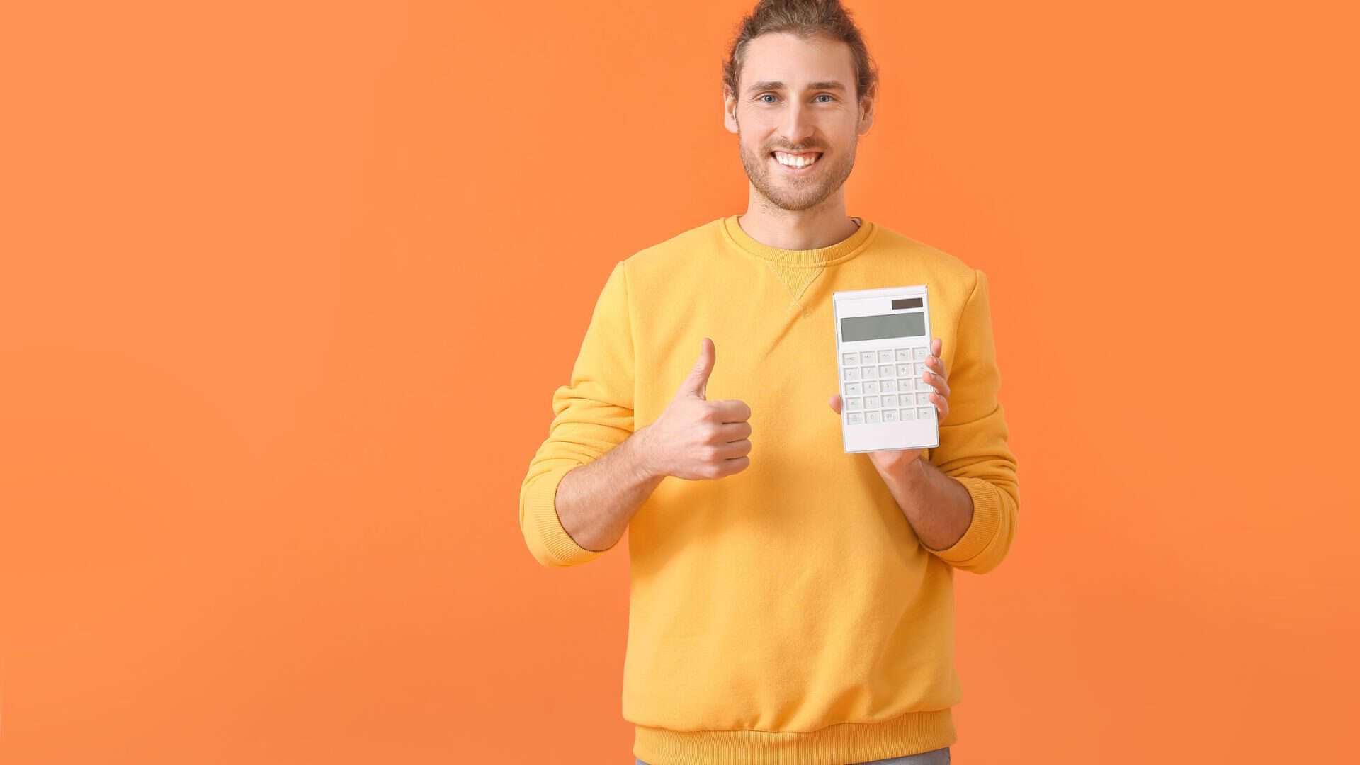 A man with yellow sweater holding a calculator with thumbs up on orange background. marketing audit for small business