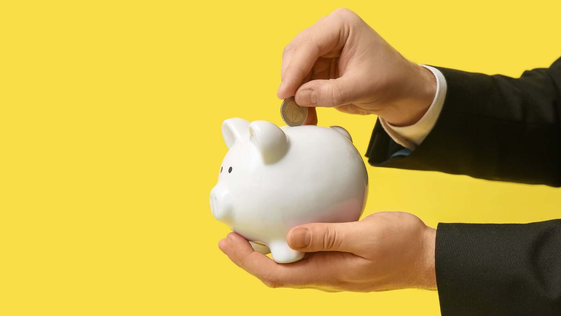 comment exiger un acompte de ses clients - homme déposant de l'argent dans une tirelire